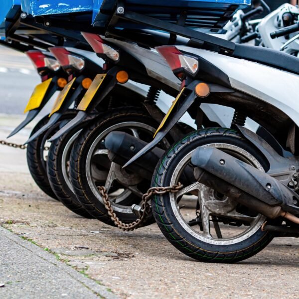 The rear wheels of the pizza delivery scooter chain are locked with an anti-theft chain - image